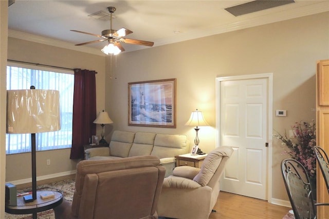 living room with ceiling fan, ornamental molding, and light hardwood / wood-style flooring