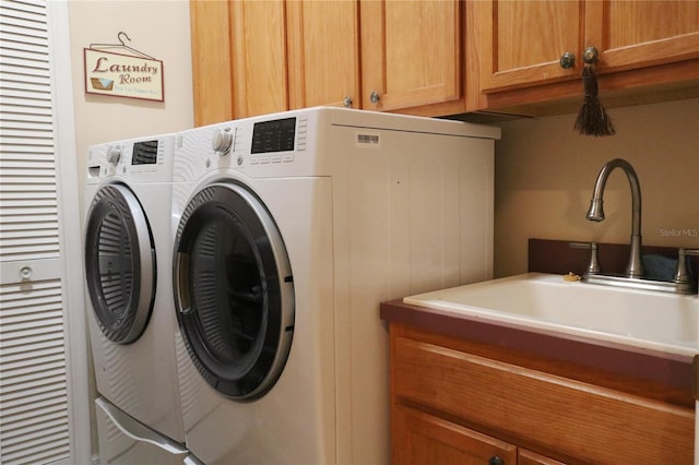 washroom featuring washer and dryer, cabinets, and sink