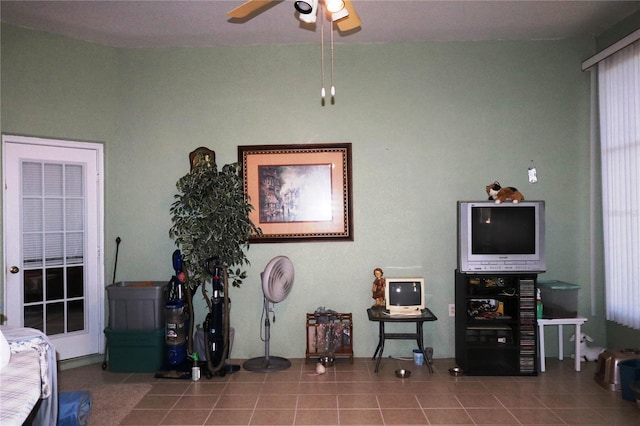 living area with tile patterned floors and ceiling fan