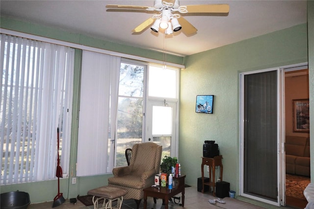 sunroom / solarium featuring ceiling fan