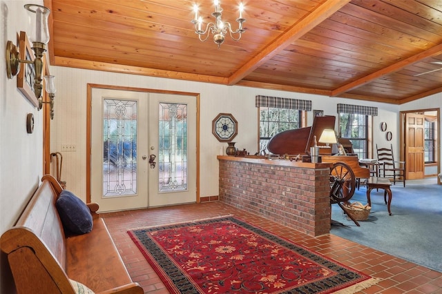 foyer featuring lofted ceiling with beams, an inviting chandelier, wooden ceiling, and french doors