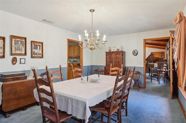 dining space with carpet, a textured ceiling, and a chandelier