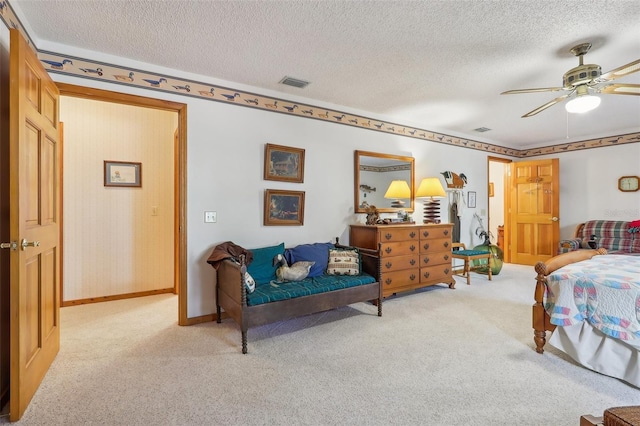 bedroom with ceiling fan, light carpet, and a textured ceiling