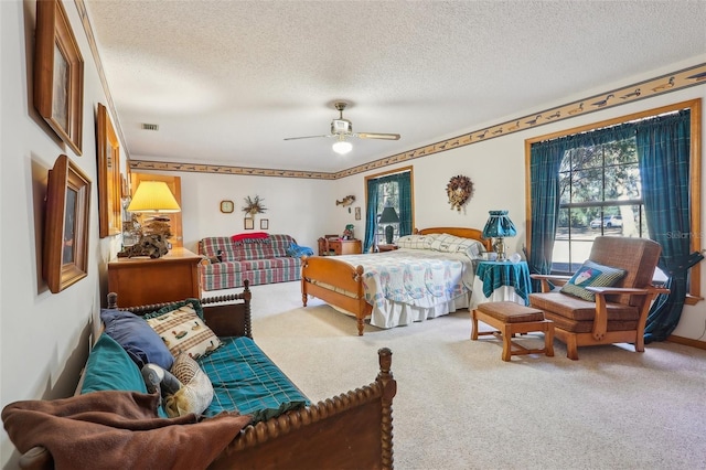 carpeted bedroom featuring ceiling fan and a textured ceiling