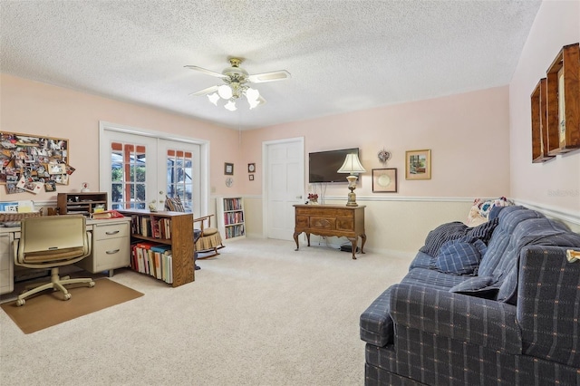 home office featuring light carpet, french doors, a textured ceiling, and ceiling fan