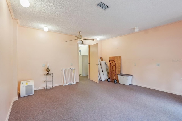 unfurnished room featuring ceiling fan, light colored carpet, ornamental molding, and a textured ceiling