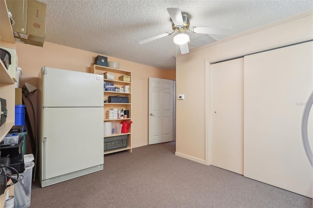 interior space featuring ceiling fan, white refrigerator, a textured ceiling, and dark carpet