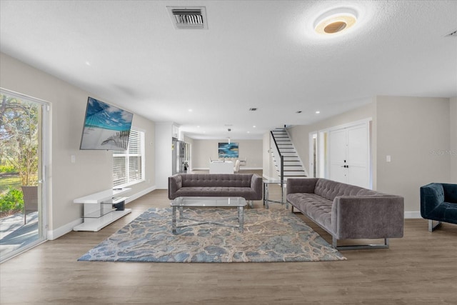 living room featuring wood-type flooring and a textured ceiling