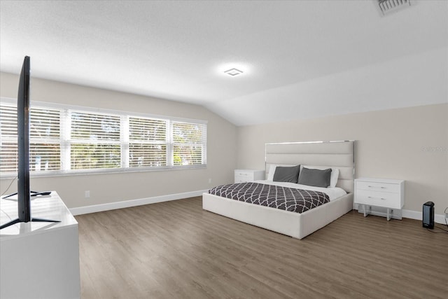 bedroom featuring hardwood / wood-style floors and vaulted ceiling