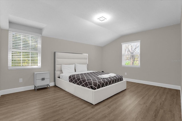 bedroom featuring hardwood / wood-style floors and lofted ceiling