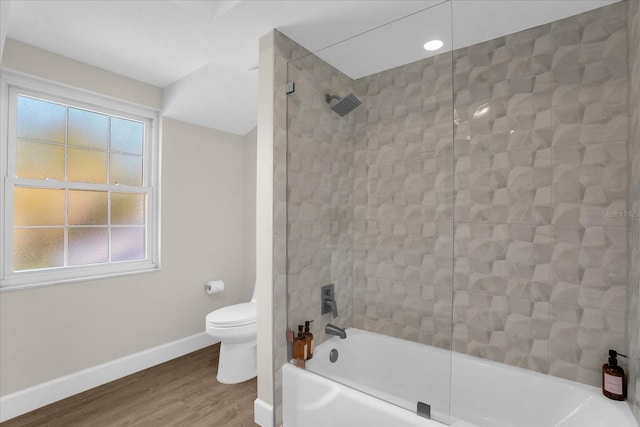 bathroom featuring bathtub / shower combination, hardwood / wood-style flooring, toilet, and a wealth of natural light