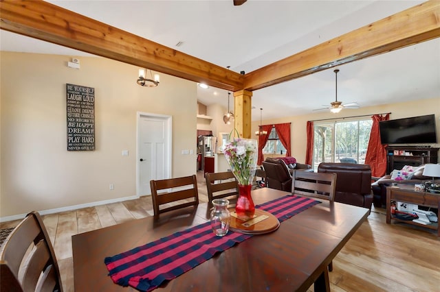 dining room with light wood-type flooring, ceiling fan with notable chandelier, and lofted ceiling with beams