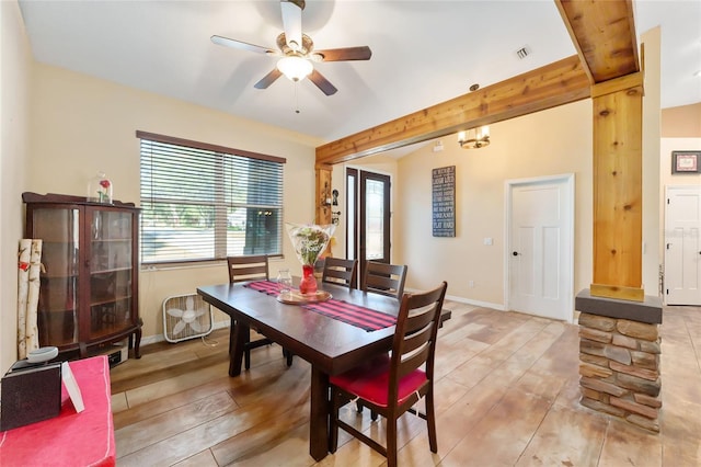 dining space featuring ceiling fan, lofted ceiling with beams, and light wood-type flooring