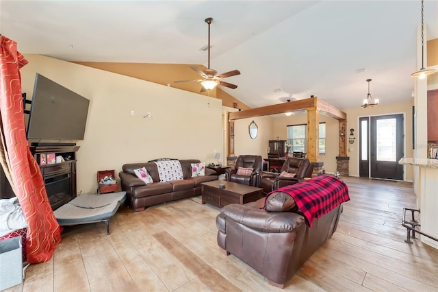 living room with light hardwood / wood-style floors, ceiling fan with notable chandelier, and vaulted ceiling