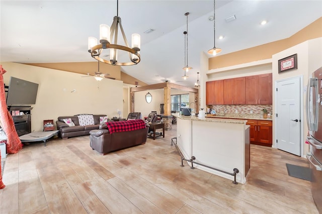 kitchen with lofted ceiling, backsplash, pendant lighting, light hardwood / wood-style flooring, and ceiling fan with notable chandelier