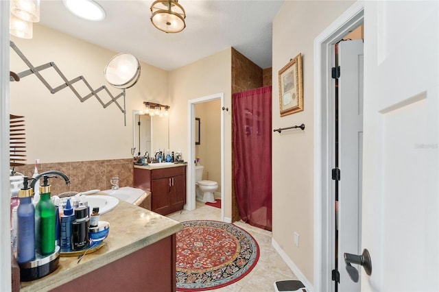 bathroom featuring toilet, tile patterned flooring, vanity, and curtained shower