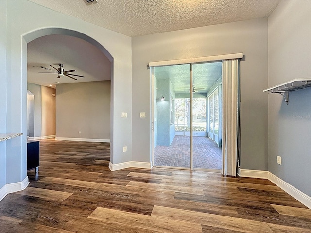 spare room featuring ceiling fan, dark hardwood / wood-style flooring, and a textured ceiling