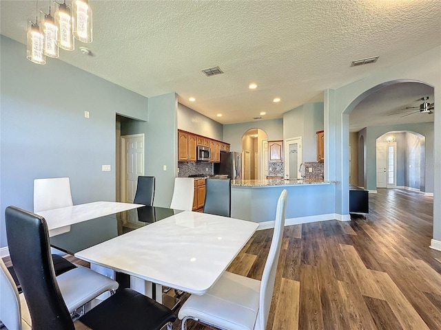 dining room with a textured ceiling and light hardwood / wood-style floors