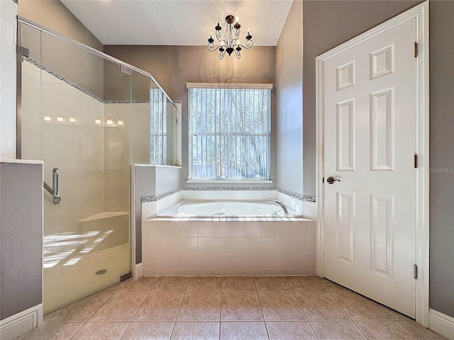 bathroom featuring tile patterned floors, a chandelier, a textured ceiling, and shower with separate bathtub