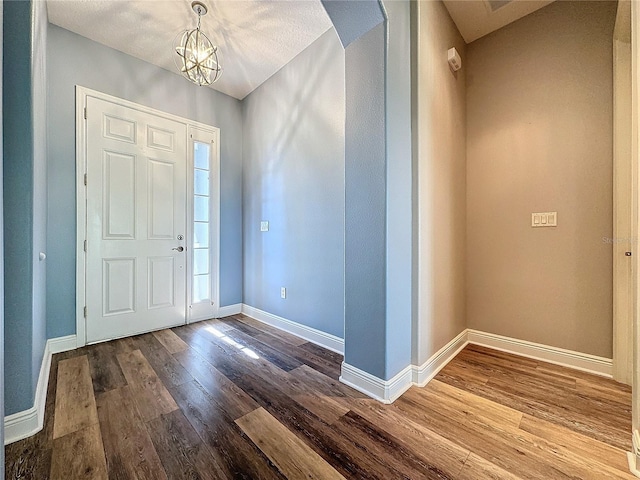 foyer with hardwood / wood-style flooring and an inviting chandelier