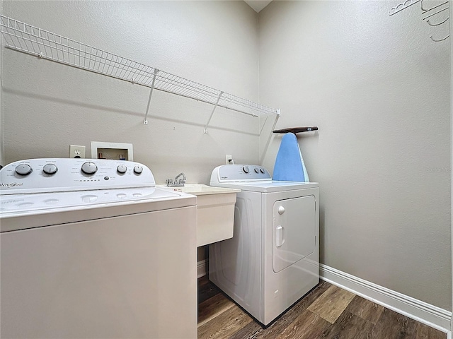 laundry area with washer and clothes dryer, dark hardwood / wood-style flooring, and sink