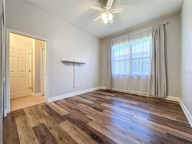 empty room featuring a textured ceiling, hardwood / wood-style flooring, and ceiling fan