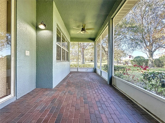 unfurnished sunroom featuring ceiling fan