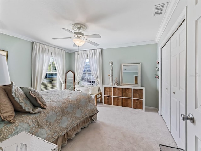 bedroom with ceiling fan, light carpet, a closet, and ornamental molding