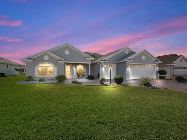 single story home featuring a garage and a yard