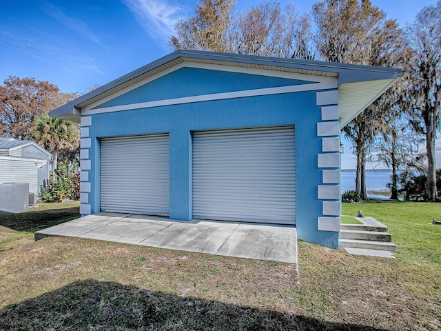 garage featuring a lawn and a water view