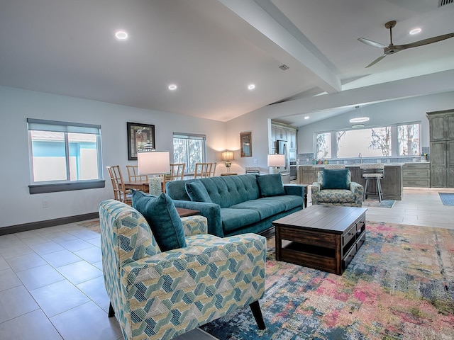 living room featuring ceiling fan, vaulted ceiling with beams, and a healthy amount of sunlight