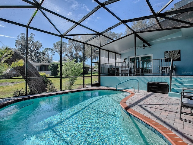 view of pool with a lanai, a patio area, and ceiling fan