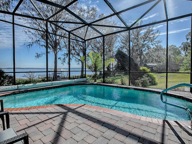 view of pool featuring a patio area, a lanai, and a water view