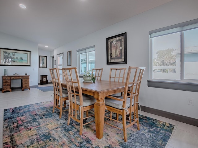 dining room with light tile patterned floors and vaulted ceiling