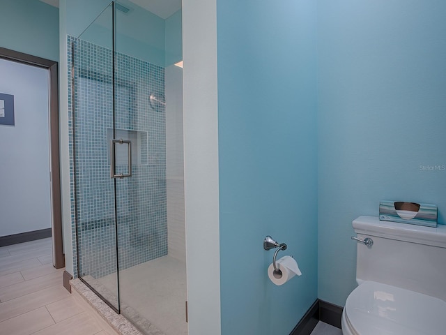 bathroom featuring toilet, walk in shower, and tile patterned flooring