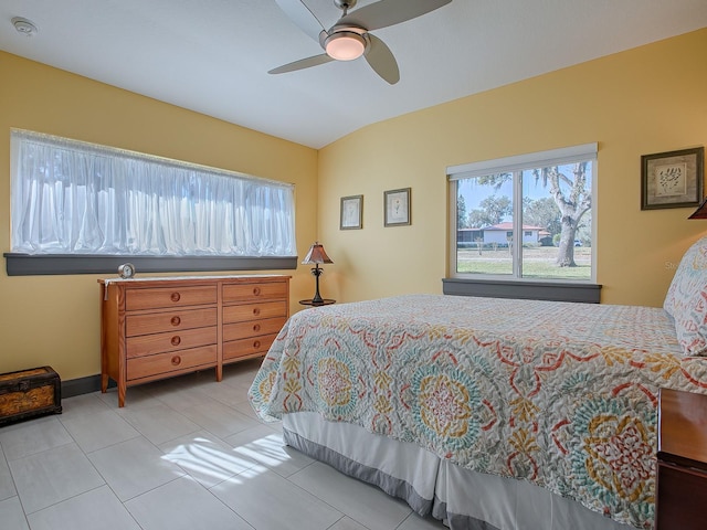 bedroom with ceiling fan, light tile patterned floors, and lofted ceiling