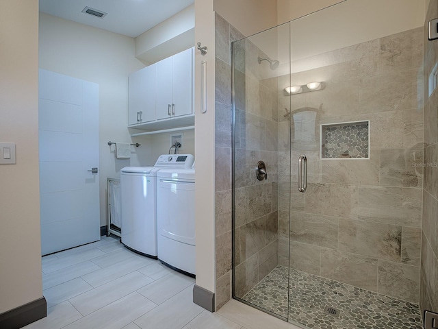 bathroom with tile patterned floors, walk in shower, and independent washer and dryer