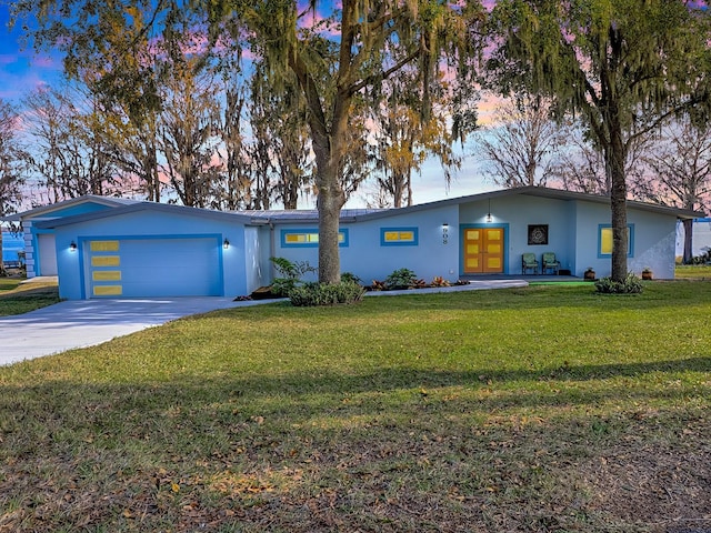 ranch-style house featuring a yard and a garage