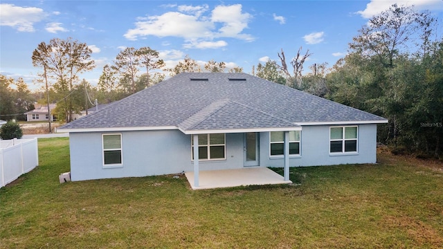 rear view of house with a yard and a patio