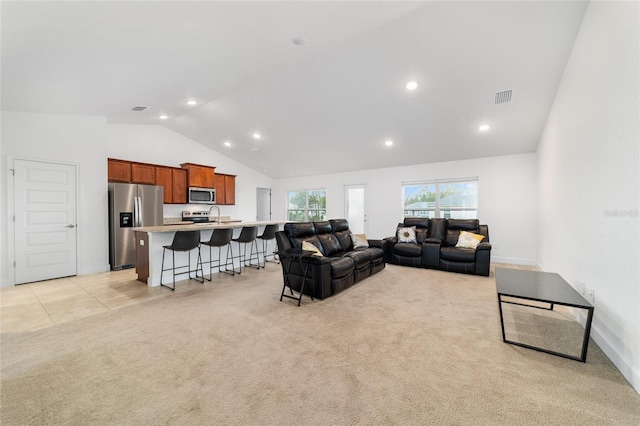 living room featuring sink, light carpet, and high vaulted ceiling