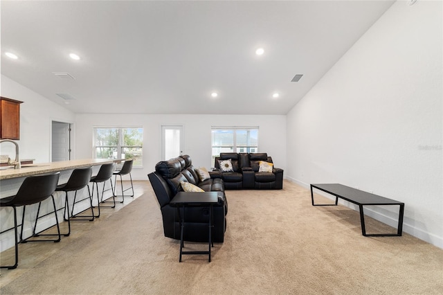 carpeted living room featuring sink and vaulted ceiling