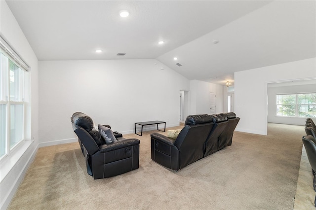 home theater room featuring vaulted ceiling and light carpet