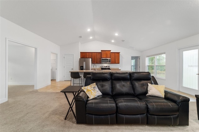 living room with light carpet, sink, and vaulted ceiling