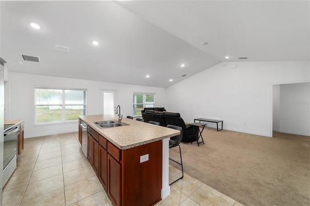 kitchen featuring an island with sink, sink, stainless steel dishwasher, light carpet, and electric stove