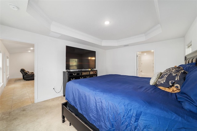 bedroom featuring crown molding, connected bathroom, a tray ceiling, and carpet flooring