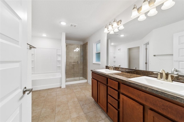 bathroom featuring tile patterned flooring, vanity, and a tile shower