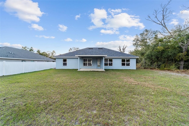 rear view of property with a yard and a patio area