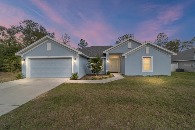 single story home with a garage, a yard, and central AC