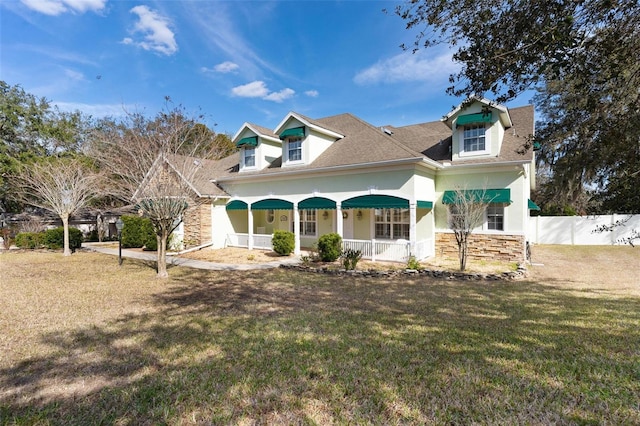 cape cod home featuring a porch and a front yard