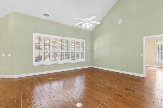 spare room featuring hardwood / wood-style floors, high vaulted ceiling, and ceiling fan